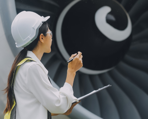 Side View Of Aerospace Inspector Standing Next To Large Turbine