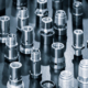 Close Up Of Various Metallic Threaded Fasteners On Dark Surface